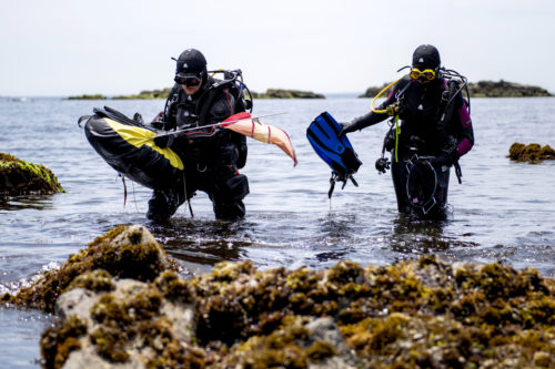06/10/19 - NAHANT, MA. - Students Jaxon Derow and Sahana Simonetti exit the water after collecting mussels for a research project at the Marine Science Center on June 10, 2019. Photo by Matthew Modoono/Northeastern University